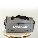 ساک ورزشی طوسی ریبوک مدل بیاله صافتی با لوگوی سفید و دسته مشکی